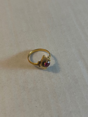 Gold ring with a circular ruby inset