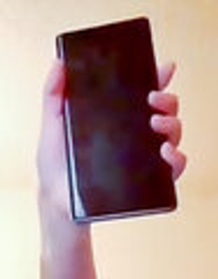 a hand holds a black rectangular phone