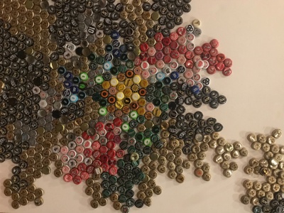 A white canvas with bottle caps 