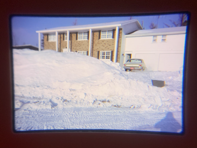 Two-storey house with snow and car.