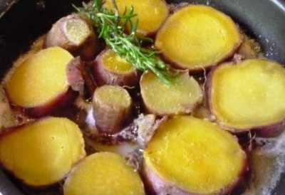 Fresh, caramelized, yellow sweet potatoes with rosemary.