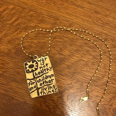 This is a photo the pendant which says, "War is not healthy for children and other living things."