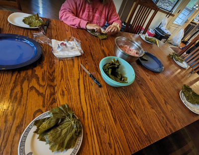 Woman rolling grape leaves at a table