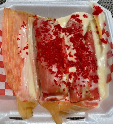 Tamales drizzled in cheese