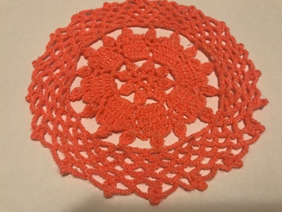 A red-orange colored blanket/carpet. Hand-knitted by my grandmother.