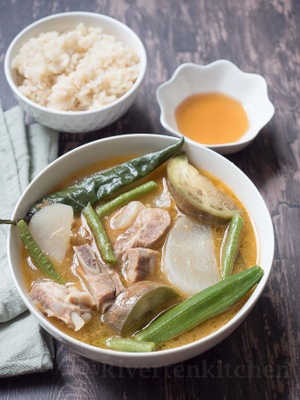 A bowl of sinigang with a side of rice 