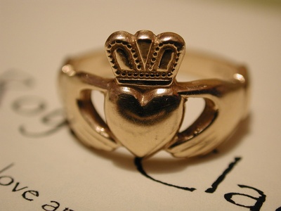 A gold Claddagh ring on a religious book