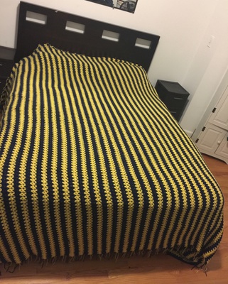 Blue and yellow crocheted bedspread