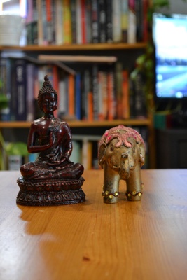 A wooden buddha and a clay elephant.