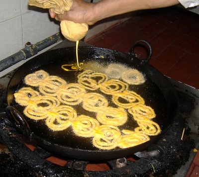 man making jalebi with the roller