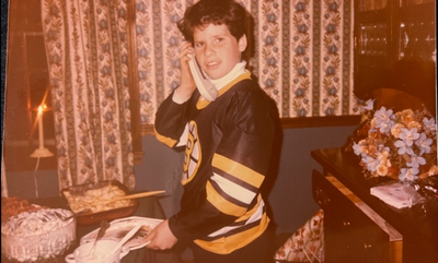 Teen holding a phone wearing Bruins gear