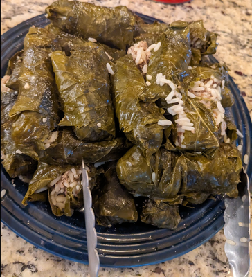 Cooked grape leaves piled on a plate