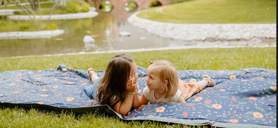 Two babies on a picnic blanket. 