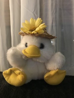 Stuffed white duck with a straw hat