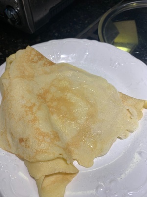 (An unrolled crepe with butter and sugar on it)