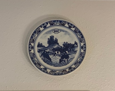 Delft Blue plate depicting grazing cows in a lush field