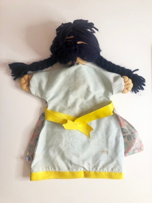 Light blue dress and apron made out of floral fabric, yellow ribbon around