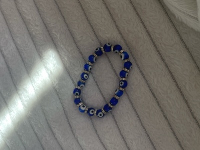 a blue beaded bracelet with eyes drawn