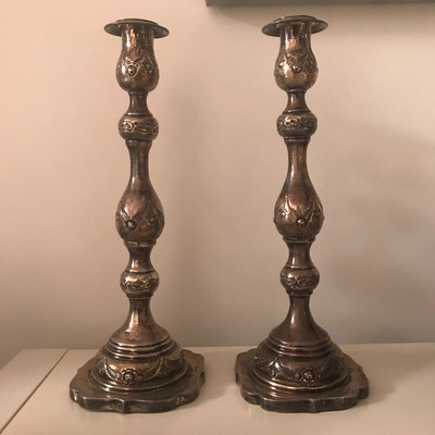 These are the silver Shabbat candlesticks. They are beautifully shaped and are adorned with engravings all around them.