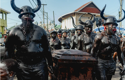 Men covered in black carrying a casket